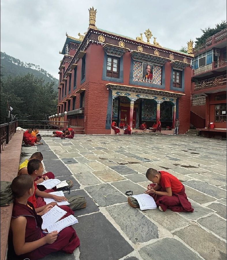 Children studying outdoors in the monastery courtyard